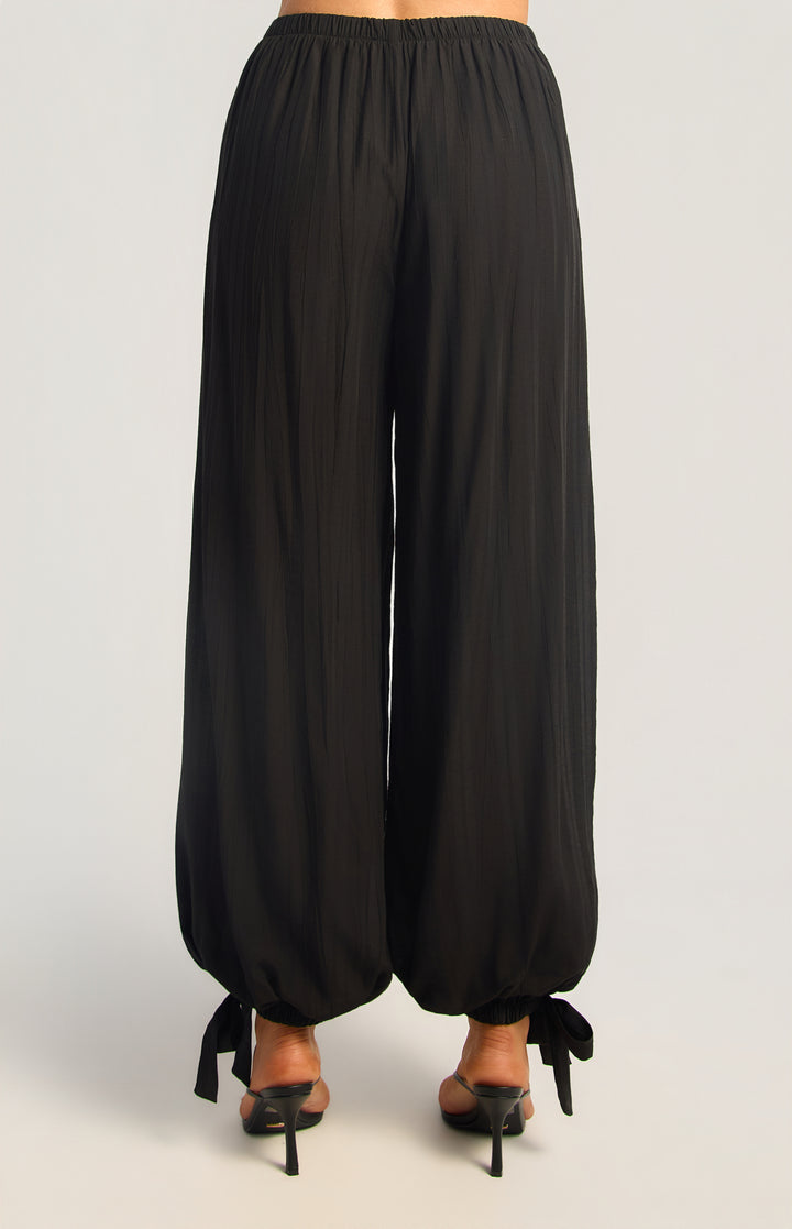 Textured balloon hem pants in black, back view